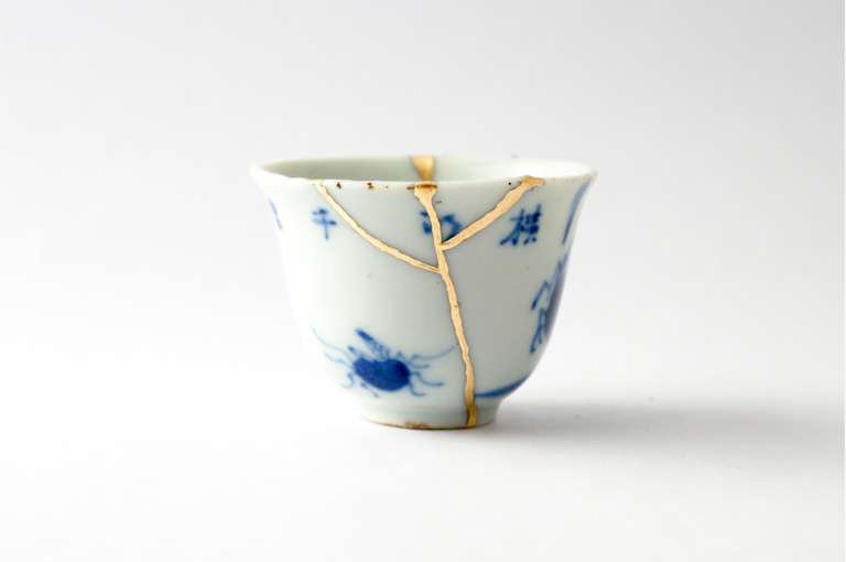 Teacup restored with Kintsugi, featuring gold-filled cracks that highlight the beauty of imperfection and the art of mending broken pottery