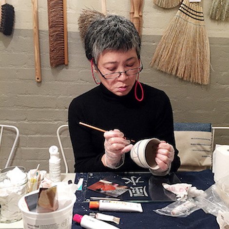 Iku Nishikawa, a renowned Kintsugi artist, skillfully repairing pottery with gold, highlighting the beauty of imperfections and the art of restoration